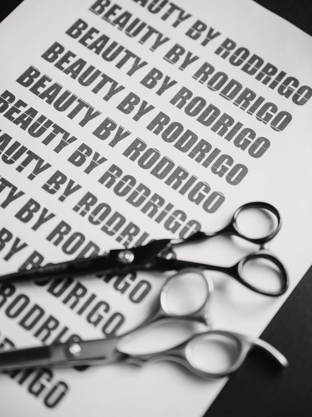 Tijeras sobre papel impreso con BEAUTY BY RODRIGO