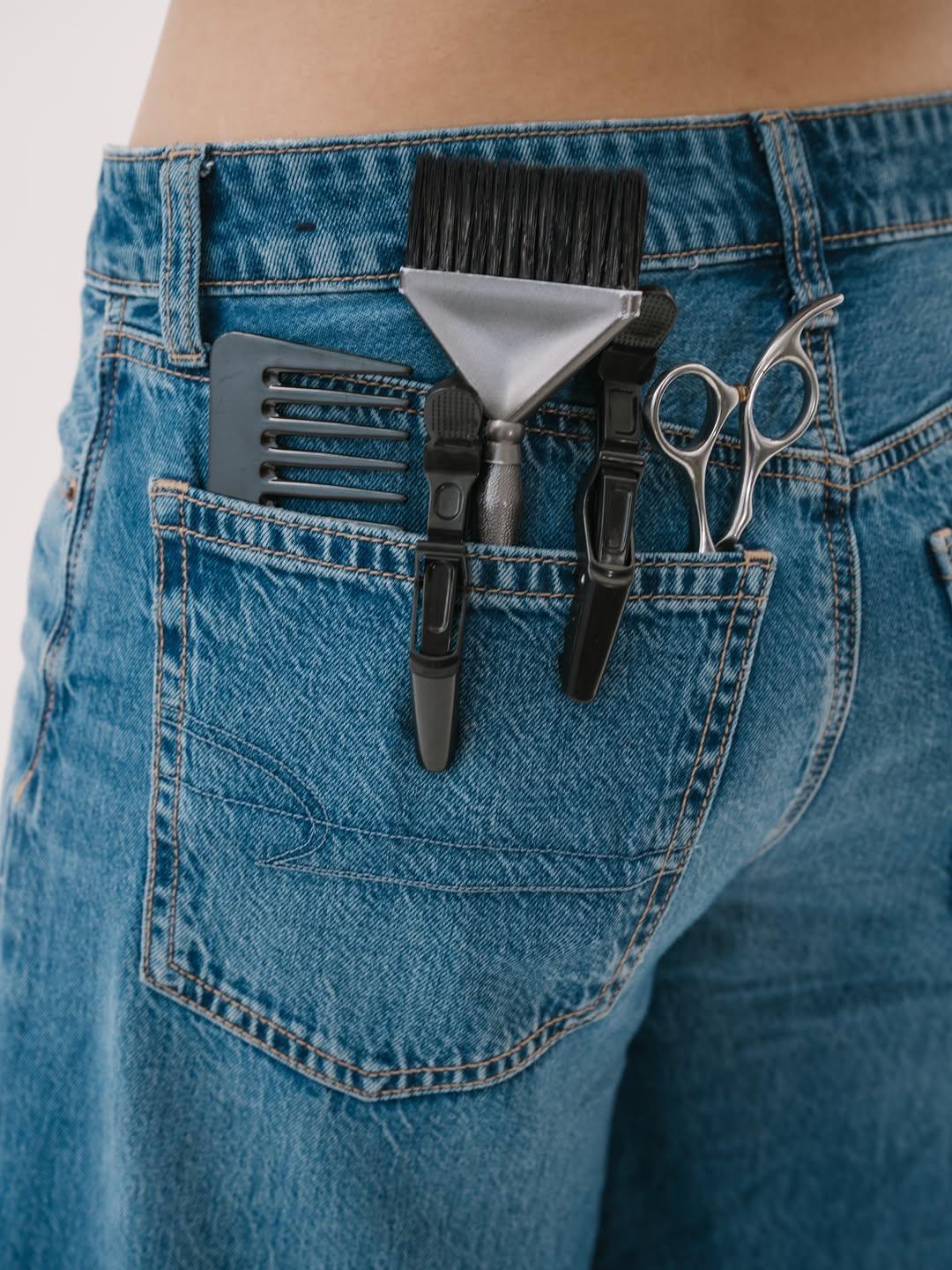 Peine, pinzas y tijera en el bolsillo trasero de un jean